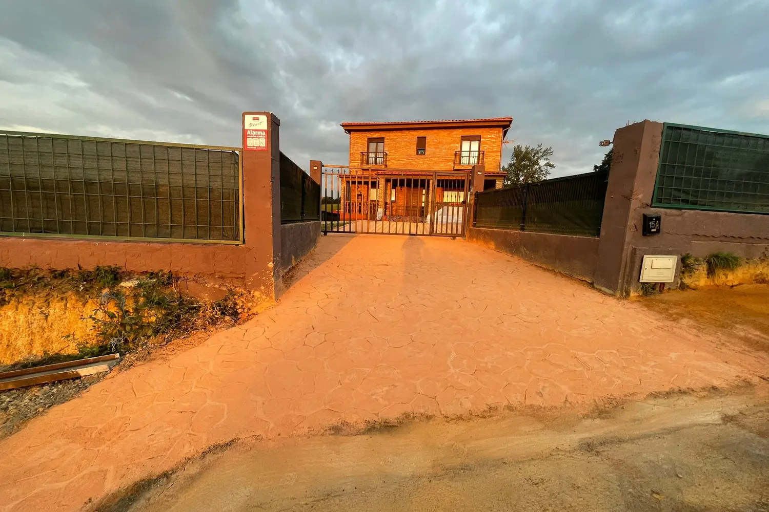 Camino de acceso a vivienda en hormigón impreso color tierra
